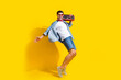 Full body photo of nice man dressed denim shirt hold boombox on shoulder dancing at summer retro party isolated on yellow color background