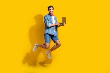 Aufkleber - Full body photo of intelligent man dressed denim shirt flying with fast internet speed on laptop isolated on yellow color background