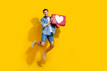 Poster - Full body photo of satisfied man dressed denim shirt flying with big social media like in hands isolated on yellow color background