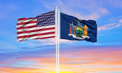 United States and New York two flags on flagpoles and blue sky.