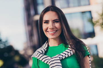 Poster - Photo of cheerful positive girl dressed green top smiling enjoying sunshine walking outdoors urban town park