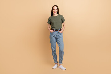 Canvas Print - Full size body photo of candid expert happy lady model wearing denim jeans with khaki t shirt posing isolated on beige color background