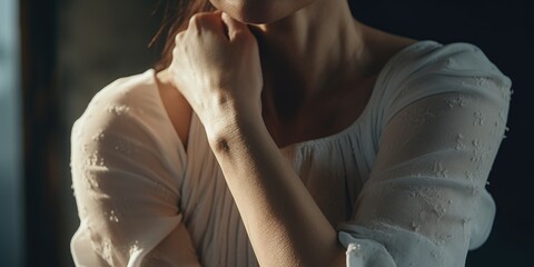 Poster - A woman wearing a white shirt holds her hand to her chin. This versatile image can be used to represent contemplation, decision-making, or thoughtful expression