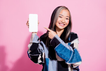 Wall Mural - photo of korean positive girl with dyed hairstyle indicating at smartphone touchscreen empty space i