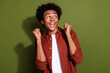Photo of ecstatic funky man with afro hairstyle dressed brown shirt look empty space win betting isolated on khaki color background