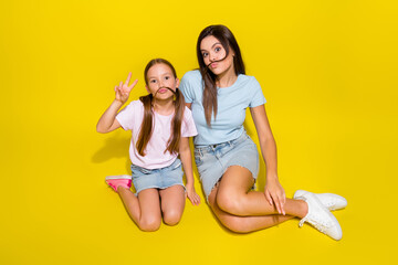 Photo of two positive girl playing game with fake curls mustache make v sign isolated over vivid color background