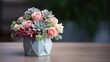 A pastel-colored bouquet of roses and succulents in a geometric white vase on a wooden table with a blurred background
