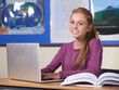 © Tylan E/peopleimages.com - Woman, student and laptop in classroom for education, learning and research with geography or scholarship books. Portrait of young person typing on computer at high school for online map information