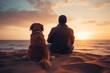 A dog and owner staring at the sunset Man and dog sitting on the sand on the beach