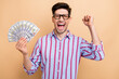 © deagreez - Photo of crazy successful millionaire businessman celebrate his new startup makes big money hold dollars isolated on beige color background