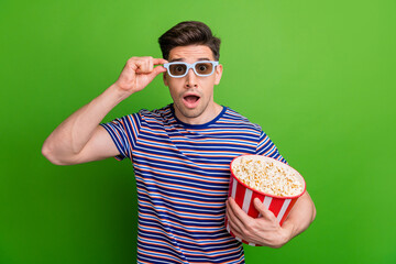 Canvas Print - Photo of impressed guy dressed striped t-shirt touching glasses staring at unbelievable visual effects isolated on green color background