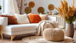 Knitted pouf near white fabric sofa with blanket and terra cotta pillows