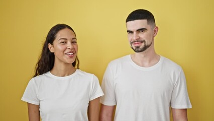 Wall Mural - Confident, beautiful couple in love gracefully sharing laughs together, positively radiating joy over a casual yellow isolated background, symbolizing happiness in their lifestyle and relationship