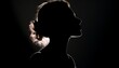 © Hannes - a silhouette of a female head with shoulders, nose up, hair tied in a plait