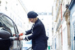 © Татьяна Волкова - Street style.Fashionably dressed blonde in black beret bright red manicure opens her car with key .