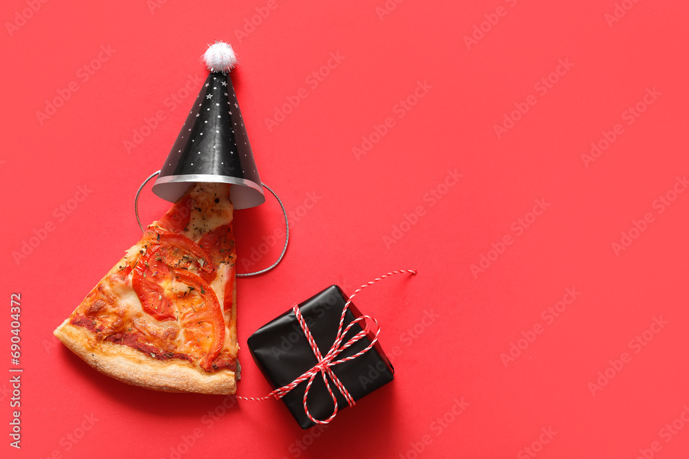 Delicious pizza slice and Christmas decor on red background