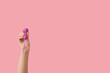 Female hand with vaginal balls on pink background