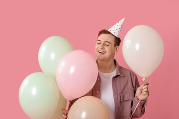 Sticker - Young man in party hat with air balloons celebrating Birthday on pink background