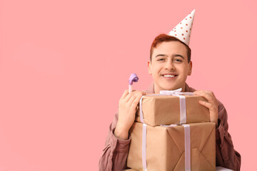 Sticker - Young man with party whistle and gift boxes celebrating Birthday on pink background