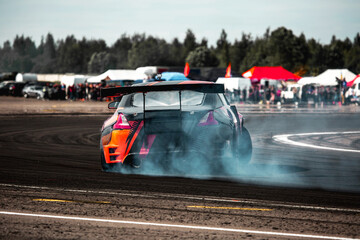 rear view of a drift car in a skid on a corner of a sports car track