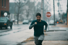 Young man running in rainy weather