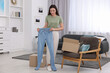 © New Africa - Happy woman with stylish light blue jeans at home. Online shopping