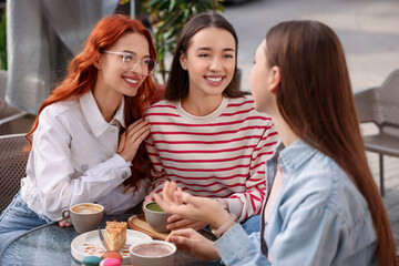 Canvas Print - Happy friends spending time together in outdoor cafe