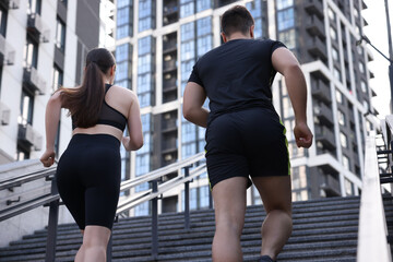 Poster - Healthy lifestyle. Couple running up steps outdoors, low angle view