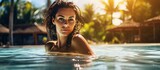 Fototapeta  - Lady swimming in Caribbean resort pool during vacation.