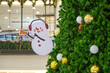 © aapsky - Snowman toy in ear warmers with a bell decoration on the New Year tree.