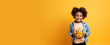 Smiling happy African American girl look straight into camera with metal robot in her hands on yellow background. Electric toys and learning robots at robotics horizontal studio banner copy paste