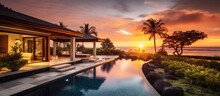 Sunset View Of A Tropical Villa With Garden, Pool, And Open Living Area.