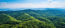 Bright Summer Day With Dense Green Lush Woods Covering Mountain Hills In Aerial View.