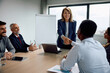 © Drazen - Female executive handshaking with colleague during business meeting in office.