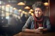 Femme de 50 ans pensive et triste à la table d'un café en journée, questions économique, dépression, divorce et solitude