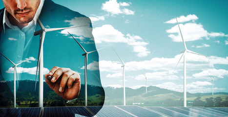 Wall Mural - Double exposure graphic of business people working over wind turbine farm and green renewable energy worker interface. Concept of sustainability development by alternative energy. uds