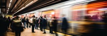 Blurred motion of a fast-moving subway train alongside a busy platform of waiting passengers.