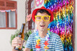 Brazilian man joyfully celebrates Carnival at home, sipping beer amidst festive decor. Ideal image to capture the spirit of people reveling in the joy of Carnival festivities