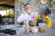© Wosunan - In the pottery workshop, an Asian retired couple is engaged in pottery making and clay painting activities.
