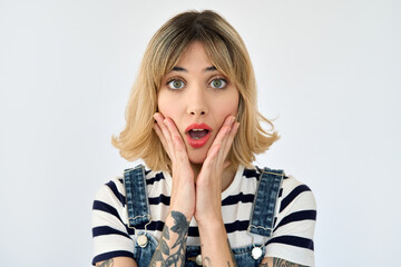 Shocked pretty gen z blonde young woman, surprised 20s girl with short blond hair and tattoos looking at camera feeling amazed or excited emotion isolated on white background. Close up face portrait.