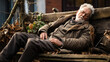 anziano signore con barba bianca addormentato su una panchina, 