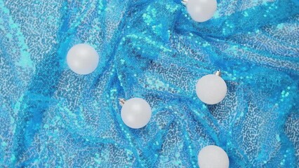 Wall Mural - Christmas light blue background. Glass Christmas bauble on shiny sequin fabric. Slow motion. New Year decoration