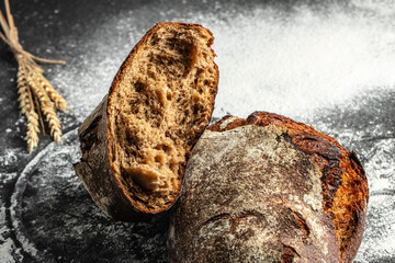 Wall Mural - Fresh bread on table. healthy eating and traditional bakery on a dark background. banner, menu, recipe place for text, top view