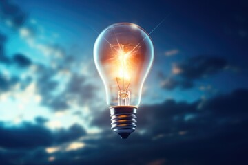 Poster - A glowing light bulb shines brightly against a cloudy sky. This versatile image can be used to convey ideas such as creativity, innovation, inspiration, and bright ideas