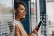 © Yaroslav Astakhov - Stylish business woman is using phone standing in office during break time. High quality photo