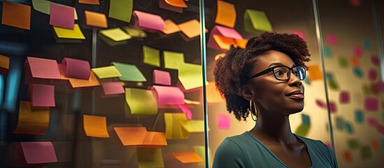 African woman leading team, utilizing sticky notes for business presentation and teamwork collaboration during brainstorming and strategy sessions.