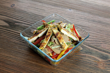 Wall Mural - Chicken and mushroom salad with tomato and cucumber served in dish isolated on wooden table side view of arabic food