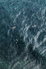 Aerial View Of Three Surfers Waiting Waves Seated In Surfboards, Textured Patterns Of The Ocean In Indonesia, Asia