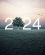 2024 white letter with tree on green grass field over aerial view of cityscape at sunset, vintage style, Happy new year 2024 ecological concept