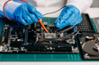 The technician is putting the CPU on the socket of the computer motherboard. electronic engineering electronic repair, electronics measuring and testing, repair..